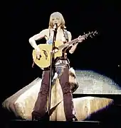 Image of Madonna playing the acoustic guitar during a concert