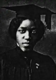 A young Black woman wearing an academic cap and gown