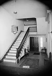 Historic American Buildings Survey photo of the first floor hallway with staircase, taken in 1936.