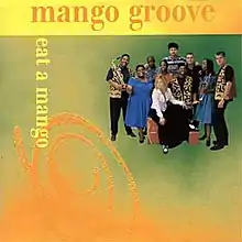 The album cover has a green, orange, and yellow colour scheme. The band's name is in orange serif type along the top of the cover. The album title is in yellow serif type, and runs vertically on the left side of the cover. Opposite the album title is a group photo of the band with their instruments.