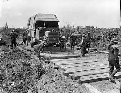 H61. The New Zealand Pioneer Battalion laying a road at Messines, Belgium, 1917, immediately after the advance. Photo: Henry Armytage Sanders