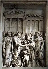 Bas=relief of family group, with an animal, outside large building with columns