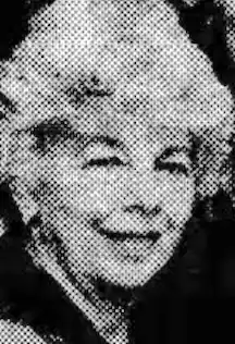 A smiling older white woman with white hair