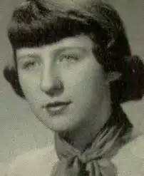 A young white woman with hair cut in straight dark bangs, wearing a neckerchief