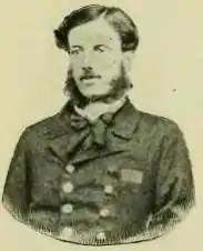 Half-length photographic portrait of a dark-haired man with sideburns who wears a double-breasted naval frock coat