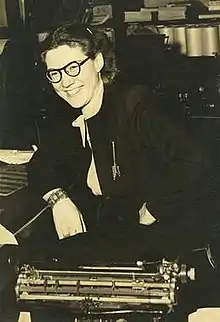 Woman seated behind a typewriter