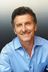 A smiling Macri in a light-blue shirt