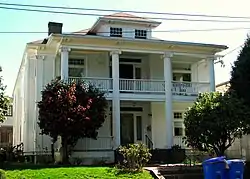 Photograph of the McAvinney Fourplex, a two-and-a-half-story house with a pillared front portico