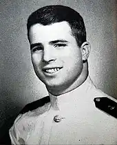 Formal portrait of young, dark-haired man in white naval uniform