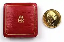 the obverse and reverse of a gold medallion. The obverse side has a portrait of King William IV. The reverse side shows a figure of Britannia, wearing a helmet and standing by a sextant and globe. She is holding a wreath in her outstretched right hand and a map in the left.