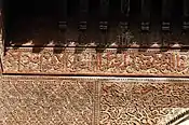 Detail of wood-carved inscriptions and arabesque motifs