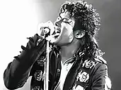 Black-and-white image of Michael Jackson singing to a microphone