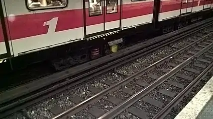 A train on Milan Metro's Line 1 showing the fourth-rail contact shoe.