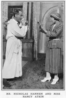 young white man in bathrobe with young white woman in 1920s day clothes