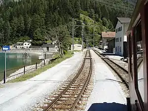 The station, with lake and station building to the left, and village houses to the right