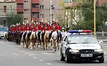 A mounted cavalry unit of the guard being escorted by local police during a procession to Naadam.