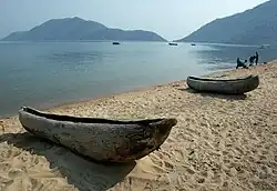 Two small dugout canoes on the shore of a lake