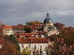 red roofed buildings, surrounded by trees, on a cloudy day