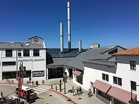 The main entrance of the Monterey Bay Aquarium and the smokestacks on its roof resemble the former Hovden Cannery that it replaced