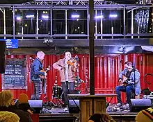 Three musicians outdoor on a stage