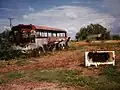 Remnants of bus and bathtub in ruins at center in June 1997