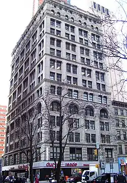 The eastern facade of the Mutual Reserve Building, seen from Duane Street during the winter. There are trees in the foreground.