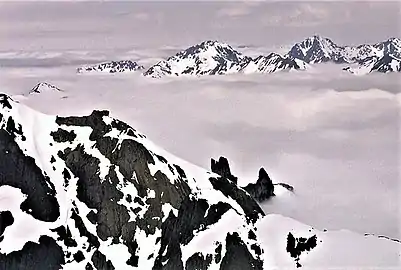 The two prominent peaks in the distance are Mts. Mystery and Deception.Hal Foss Peak can be seen between them. View is from Mt. Constance.