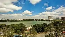 A lake as viewed from a tall building. The lake is in a populated area with a road.