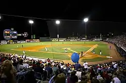 The green baseball field illuminated for a night game