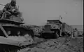 US Navy Seabee bulldozer is used to get a truck loaded with cargo ashore