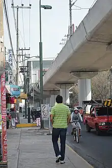 Photograph of a concrete bridge above an avenue