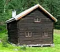 "Nestegardstugu fra Nestegard i Hovet" - This loft house from Nestegard in Hovet was built in the beginning of the 18th century as a living room and guest room with sleeping loft upstairs. It has 2 floors, built in timber and with peat roofs. The first floor is a 3-room stugu with hallway, stugu and stick. Roofs, walls, cabinets and bed are painted in the Rosemåling style by Kittil Rygg in 1759. The house was moved along with the Nestegard farm in 1751, and brought to the museum in 1936.