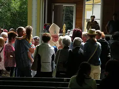 A priest talking to people after mass.