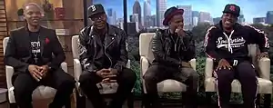 Members with Bobby Brown as New Edition during a 2018 interview.   From left to right: Ronnie DeVoe, Bobby Brown, Ricky Bell, and Michael Bivins.