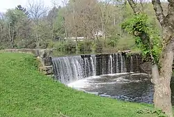 A dam across Bull Creek impounds a pond in the village park.