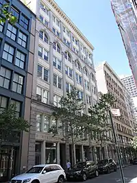 An oblique view of an 8 story white stone building.