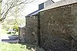 Newland Furnace.  The blowing chamber with charging floor above is to the left of the stack.  The cement scar is from a roof over the waterwheel.