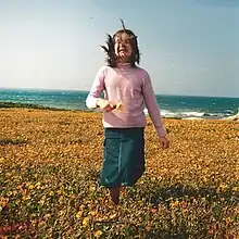 A girl running in a field, smiling