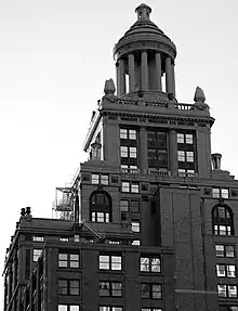  A high rise building with many tiers and a  ten-columned cupola topping it.