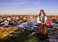 Norwegian woman wearing bunad, holding the Norwegian flag