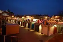 Parallel rows of market stalls with multi-coloured roofs