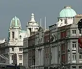 View upwards of street buildings with green-domed roofs