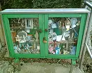 A cabinet containing offerings from pilgrims to a well