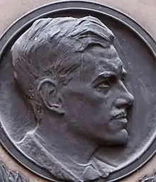 Bas-relief profile of young man with short, swept-back 1920s hairstyle and moustache