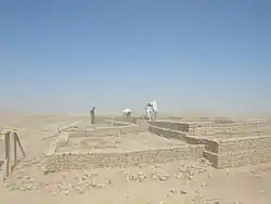 People looking at ruins in a desert