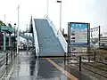 The sign says "Ōzai Station South Entrance". This footbridge leads to the forecourt next to the station building on the other side of the tracks.