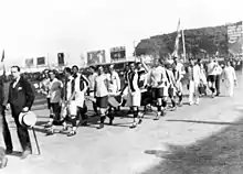 Photograph of men carrying a banner