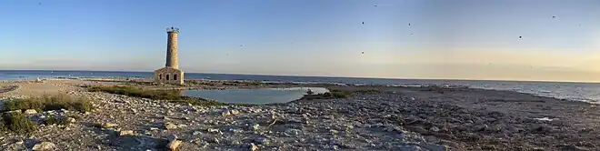 Bare rock island with ruined lighthouse and Lake Erie in the background