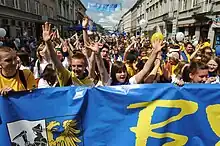 People marching behind a banner in a parade