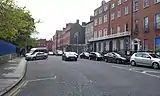 Cars along the street next to the square